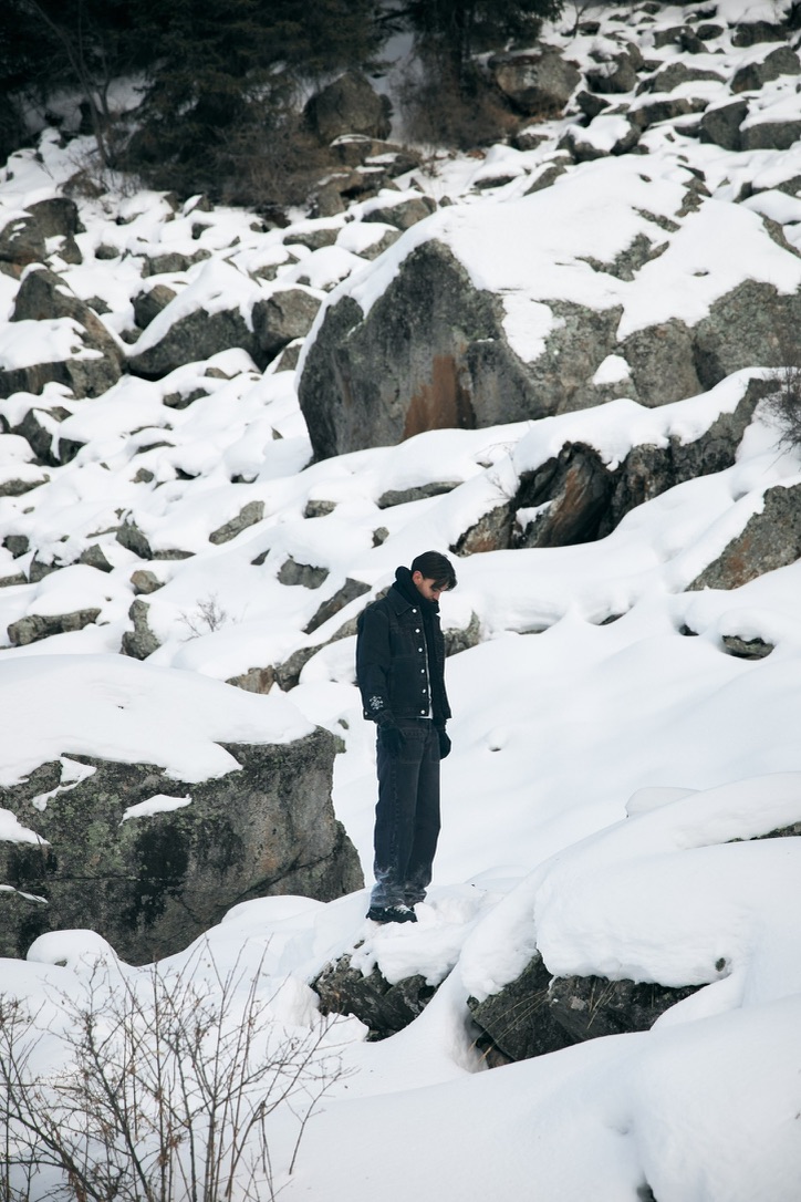 KESH denim jacket worn standing among snow-covered rocks